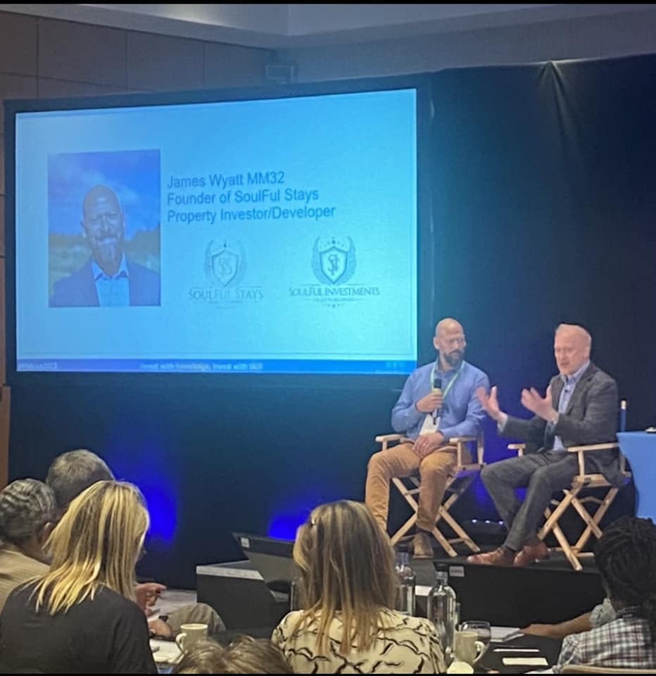 James Wyatt speaking on stage during a business and property event